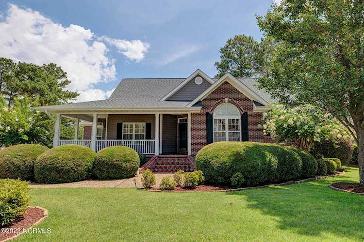 1379 Grandiflora Dr Leland, NC in Magnolia Greens. Brick home with wrap around front porch, sitting on a .27 acre lot, located on the 19th tee box of... Photo 1